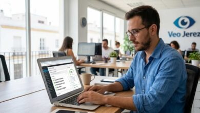Joven en oficina de Veo Jerez trabajando en su portátil con equipo de oficina.