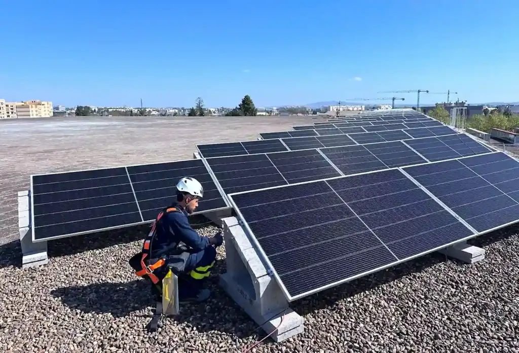 Operario instalando paneles fotovoltaicos en la cubierta del Palacio Municipal de Deportes de Chapín en Jerez.