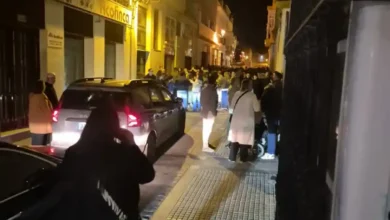 Nazareno avanzando por la calle Pérez Galdós de San Fernando mientras varios vehículos esperan durante la noche.
