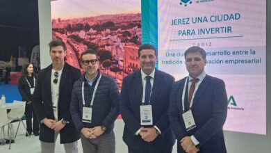 Personas en evento de movilidad eléctrica en Jerez, con cartel de inversión y innovación en eMobilit.