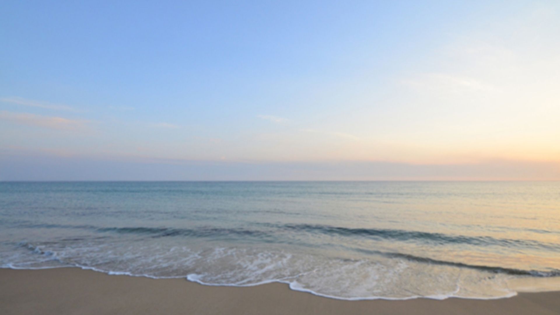 Playa con mar tranquilo y cielo despejado al atardecer en el litoral andaluz