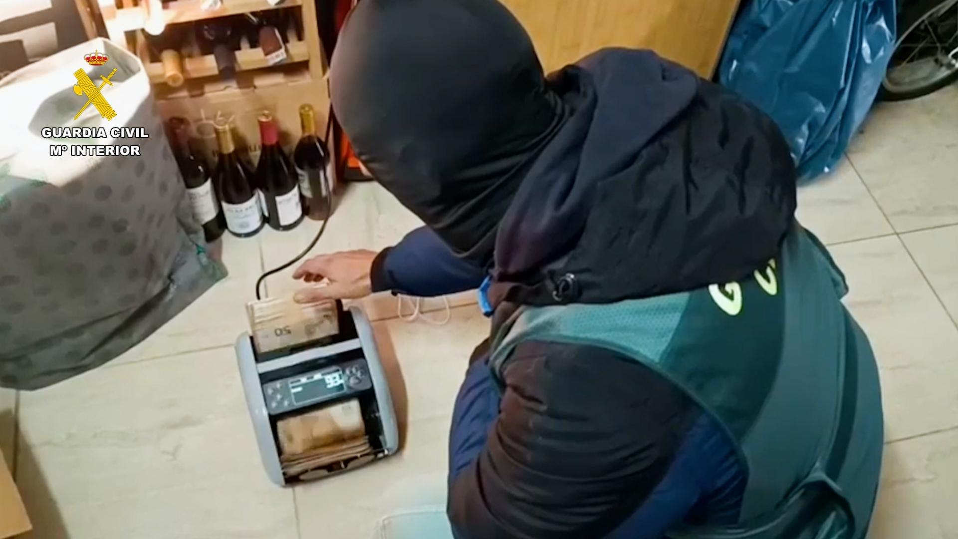 Agente de la Guardia Civil contando dinero incautado en efectivo tras desarticular el clan del Risitas