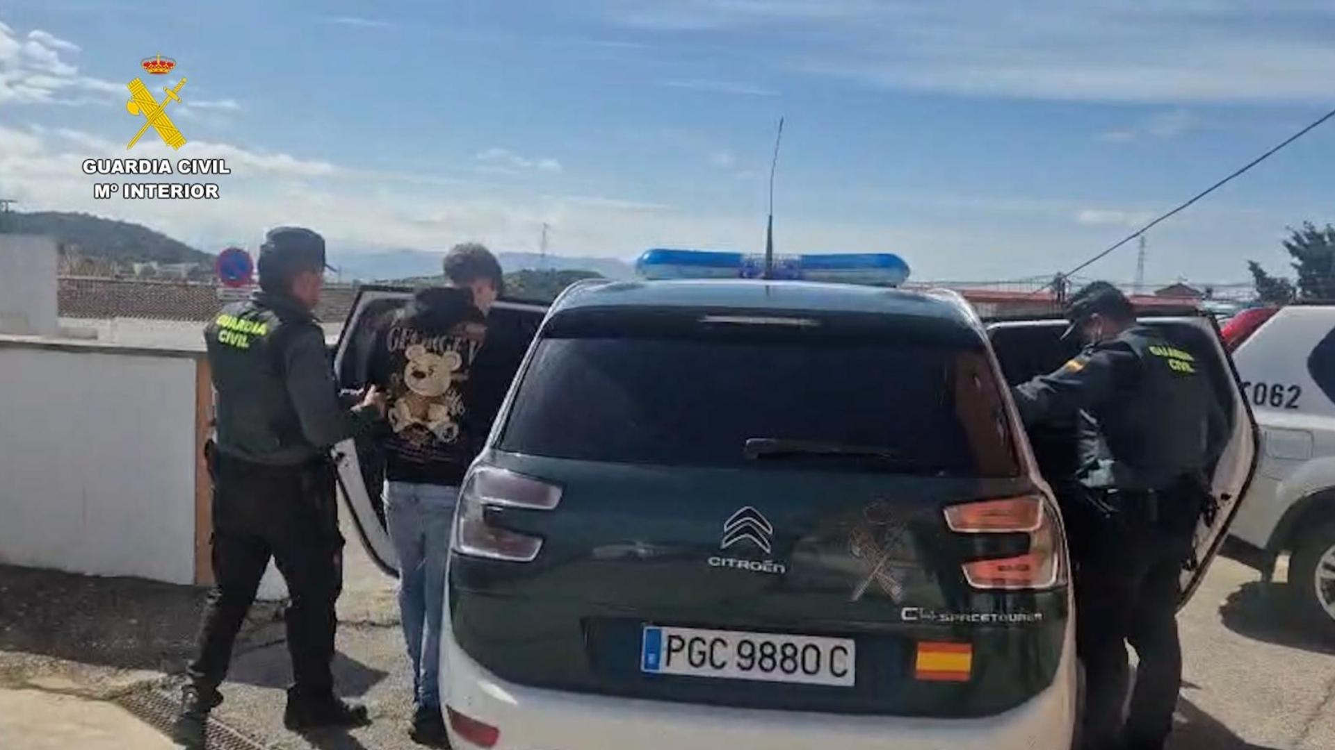 Agentes de la Guardia Civil trasladando a un detenido por el incendio de 8 vehículos en Alcalá de los Gazules.