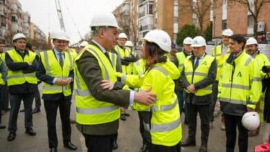 Grupo de trabajadores y supervisores en obra del Metro en Sevilla con vallas y cascos.
