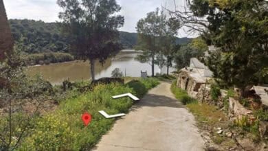 Río en El Granado, Huelva, con vegetación y camino rural cercano al puerto.