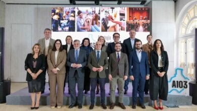 Imagen de un grupo de personas en un acto oficial en Almería, con fondo de pantallas y logotipo de A.