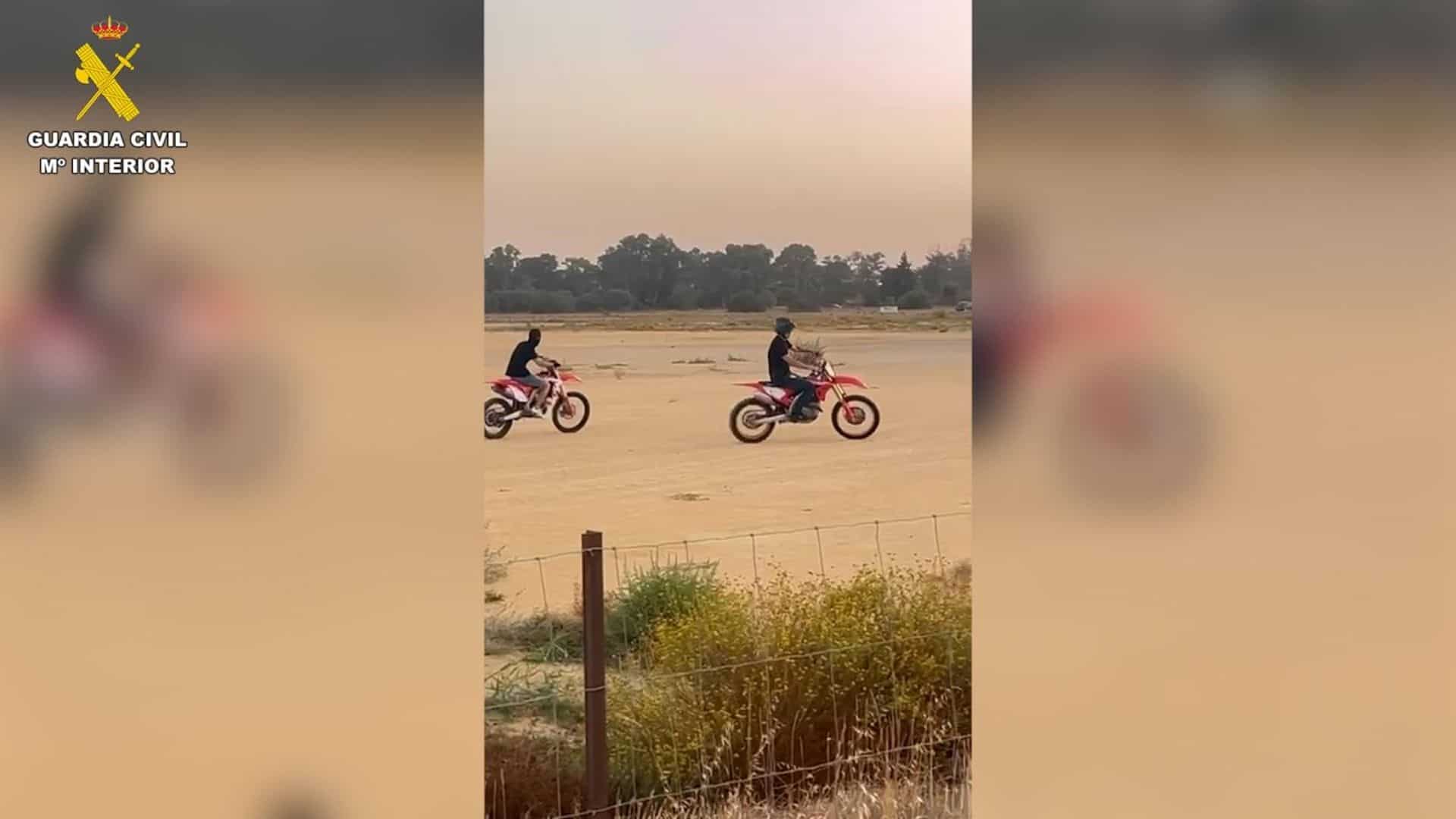Dos motoristas realizando maniobras temerarias en una explanada de Jerez durante una concentración ilegal vigilada por la Guardia Civil.