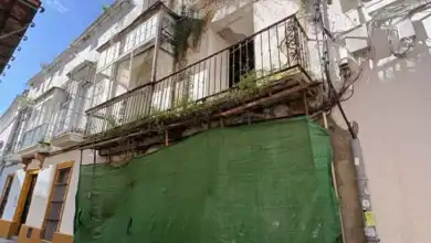 Fachada del edificio en ruina de la calle Francos 29 con mallas de protección y balcones antiguos.