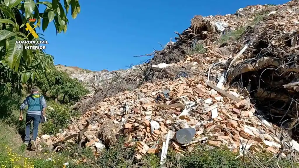 Agente de la Guardia Civil investiga un vertido ilegal de escombros en Málaga con miles de toneladas de residuos.