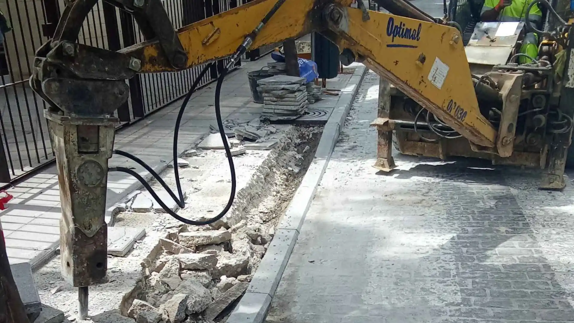 Obras de mejora de la accesibilidad calle Rosario Jerez con maquinaria trabajando en el rebaje de bordillos junto al Conservatorio.
