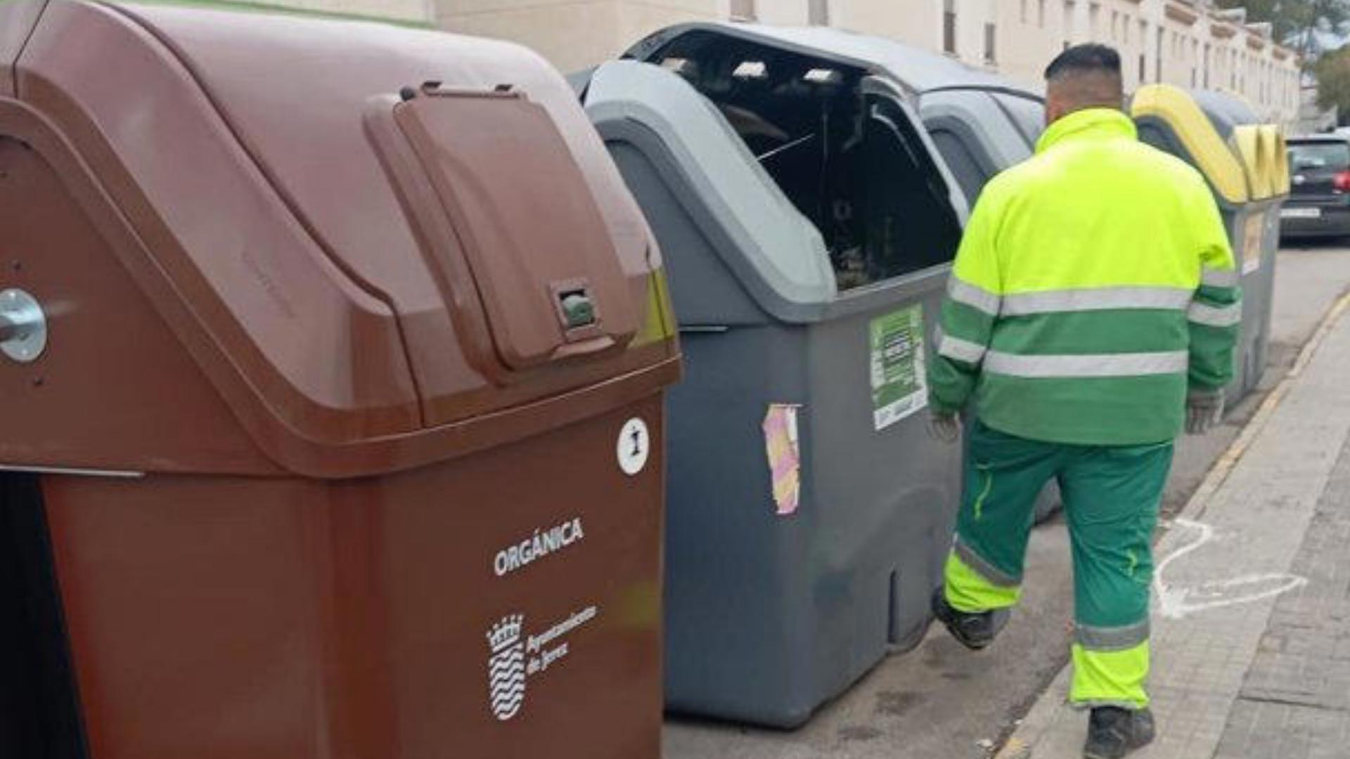 Contenedores de basura orgánica en Jerez de la Frontera con un operario de limpieza al lado.