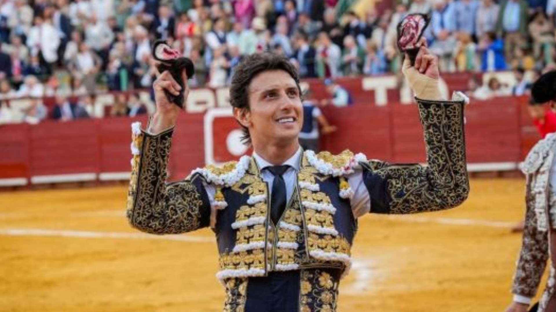 El torero Andrés Roca Rey sonríe sosteniendo las dos orejas cortadas en la plaza de toros de Jerez durante la Feria del Caballo.