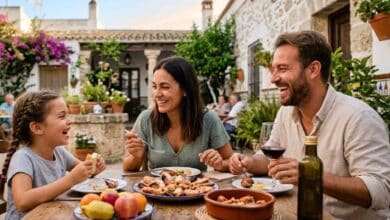 Familia sonriendo durante una comida al aire libre en un patio andaluz, reflejando por qué en Andalucía se vive mejor