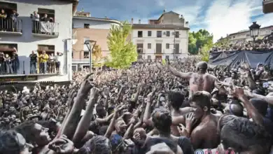 Multitud de personas cubiertas de pintura negra celebrando la fiesta tradicional del Cascamorras en Baza Granada