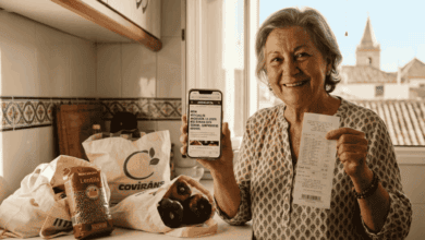 Mujer mayor mostrando recibo y productos en la cocina, compras saludables en línea en Veo Andalucia.