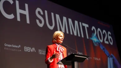 Mujer en escenario en el Tech Summit 2026 con fondo de pantalla.