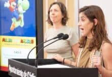 Mujer hablando en un acto público en Cádiz con pantalla de fondo.