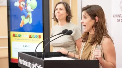 Mujer hablando en un acto público en Cádiz con pantalla de fondo.