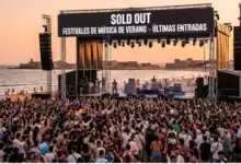 Multitud de personas en festivales de música de verano en la costa con cartel de Sold Out.