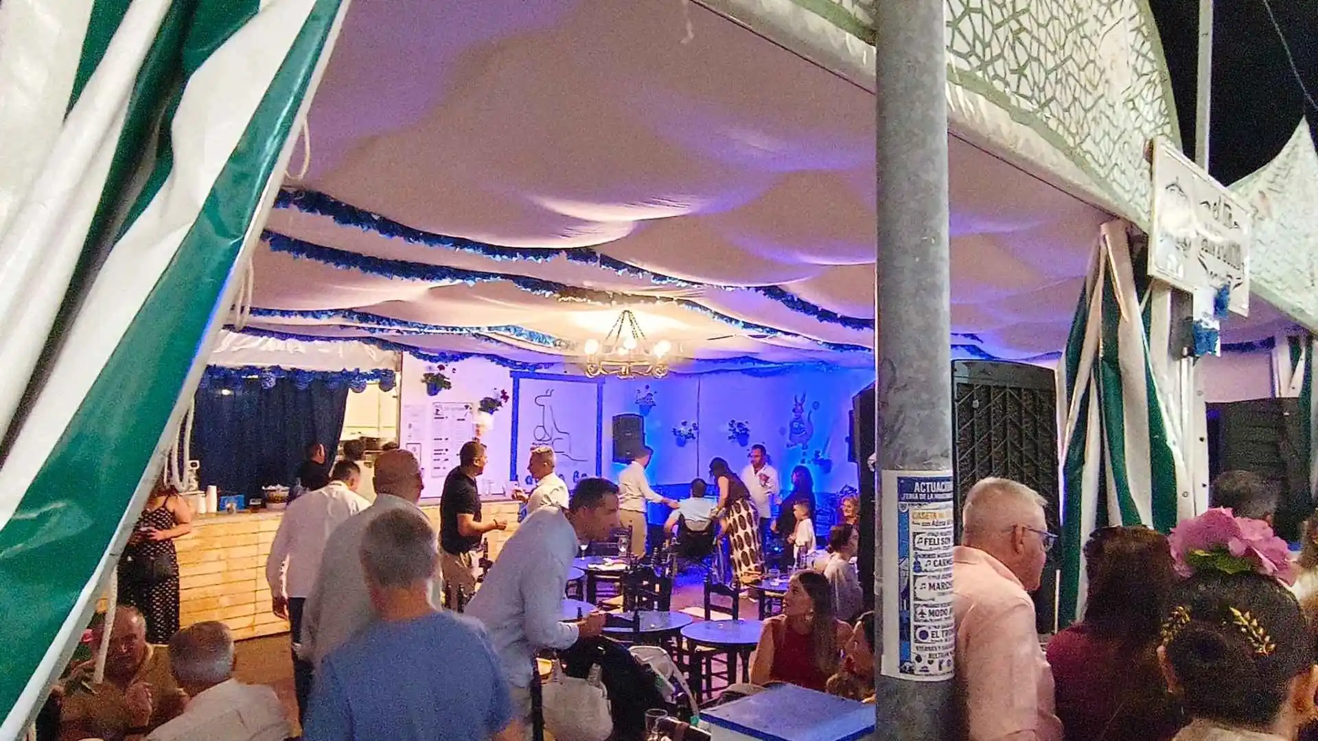 Interior de la Caseta ADESA 80 Voleibol llena de gente disfrutando de la Feria de la Manzanilla en Sanlúcar de Barrameda.