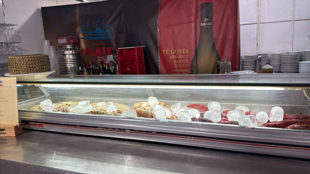 Mostrador de la caseta de Catering Almar con marisco fresco, langostinos y carabineros en la Feria de la Manzanilla.