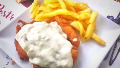 Un plato de aneto típico de Jerez con su clásica salsa cremosa por encima y acompañado de patatas fritas caseras.
