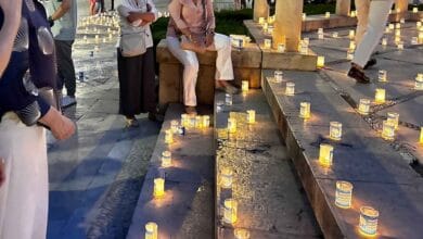 Personas junto a velas encendidas durante la X Noche de las Candelas de Aspanido en Jerez.