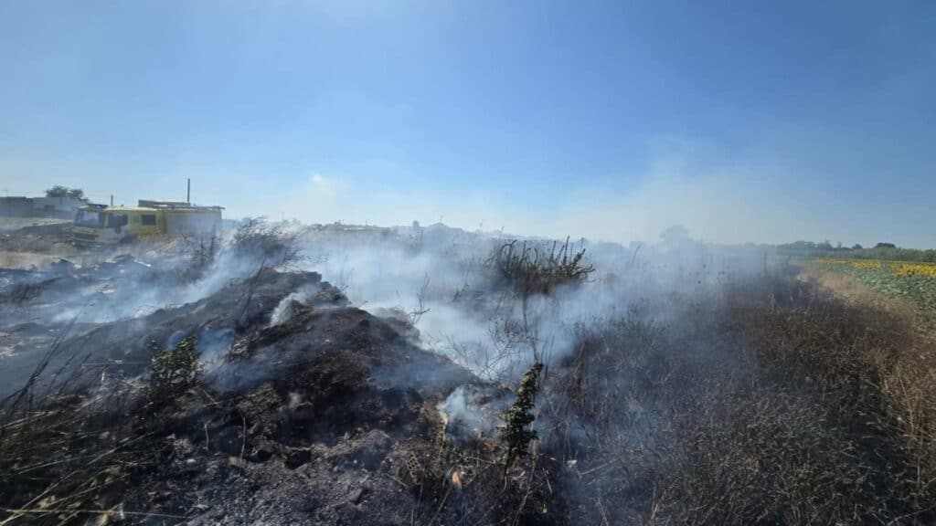 Vista del incendio en la carretera de San José Obrero a Guadalcacín con camión de bomberos sofocando las llamas.