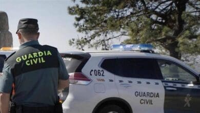 Agente de la Guardia Civil junto a un vehículo patrulla durante una operación contra productos falsificados en Cádiz.