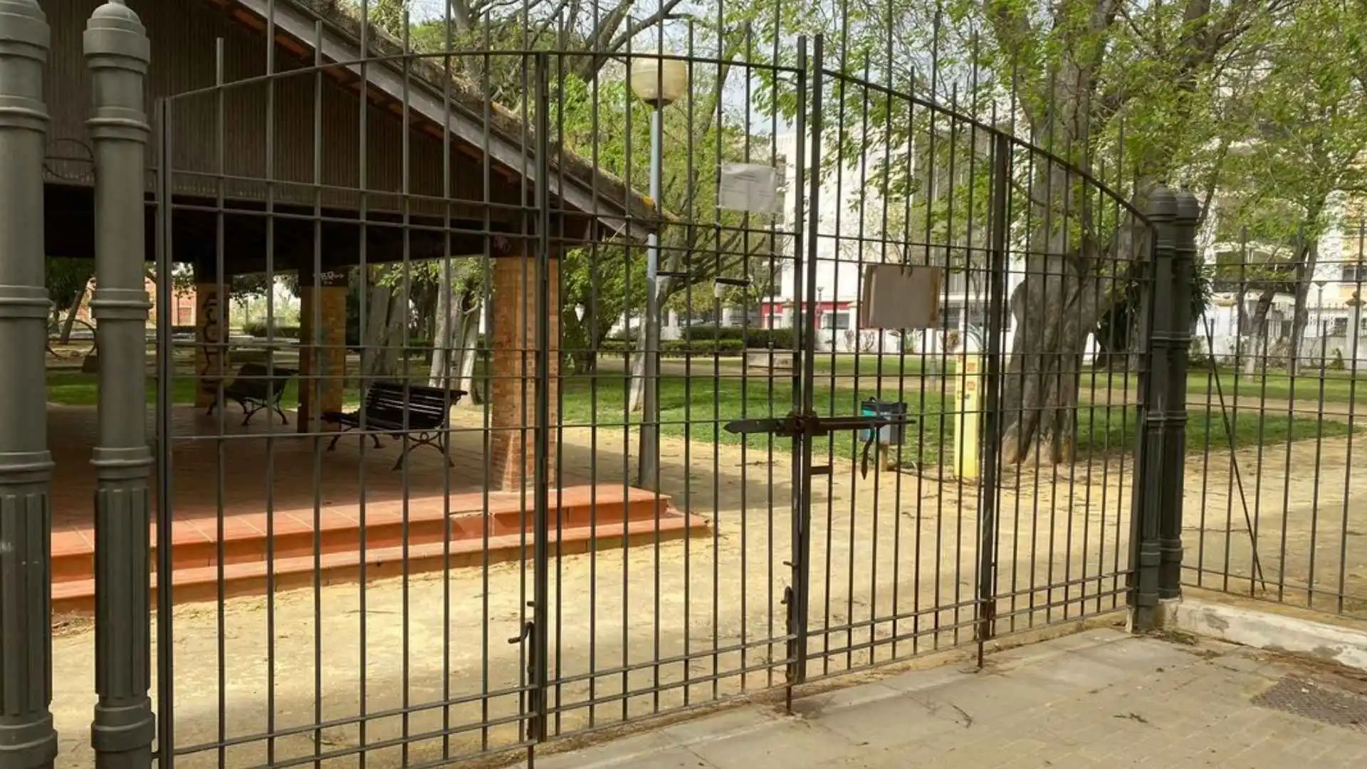 Puerta cerrada de un parque público en Jerez de la Frontera debido a la alerta naranja por fuertes vientos.