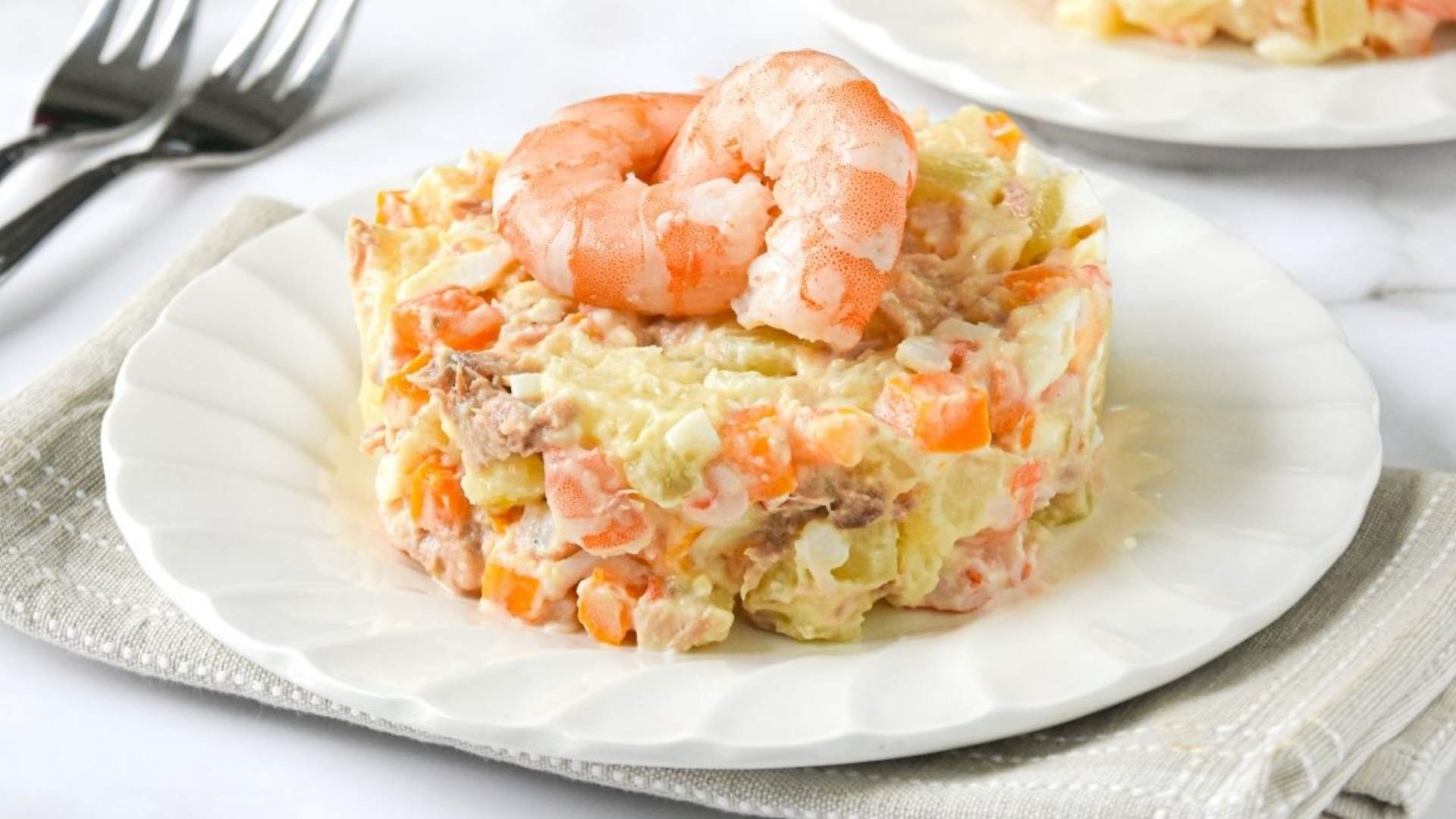 Ensaladilla de gambas casera servida en plato con tenedor al lado