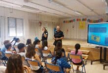Agentes de policía impartiendo una charla sobre seguridad vial y normativas de VMP a estudiantes en un colegio.
