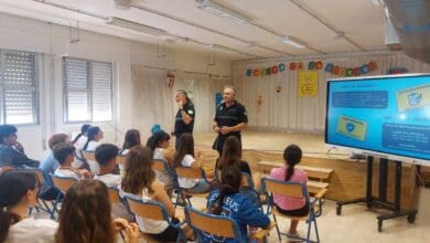 Agentes de policía impartiendo una charla sobre seguridad vial y normativas de VMP a estudiantes en un colegio.