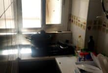 Cocina en una casa rural andaluza con utensilios y ingredientes en una encimera junto a una ventana.
