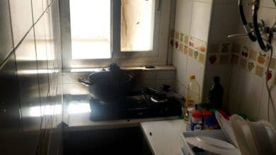 Cocina en una casa rural andaluza con utensilios y ingredientes en una encimera junto a una ventana.