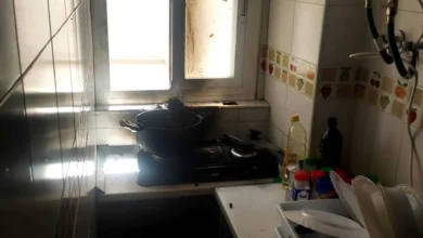 Cocina en una casa rural andaluza con utensilios y ingredientes en una encimera junto a una ventana.