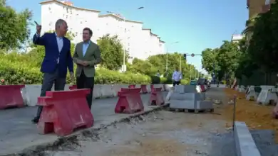 José Luis Sanz, alcalde de Sevilla, y Manuel Alés, delegado del Distrito Triana, visitando las obras de la calle Rubén Darío. La imagen muestra un entorno de obras con vallas rojas y materiales de construcción.