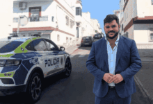 Alcalde de Arcos junto a un coche de policía en la calle.