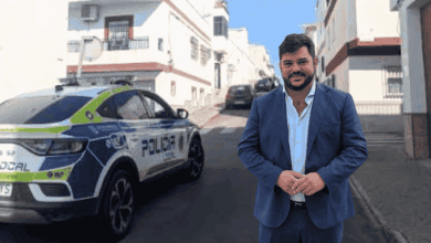Alcalde de Arcos junto a un coche de policía en la calle.