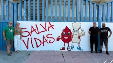 Mural artístico con el lema "Salva Vidas" y figuras animadas de donación junto a representantes municipales y el artista Pool Tattoo en Jerez.