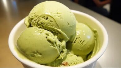 Tres bolas de helado de pistacho artesanal servidas en una taza blanca.