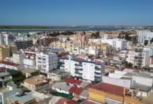 Vista aérea panorámica de la ciudad de Sanlúcar de Barrameda bajo un cielo azul despejado.