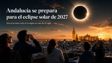Personas observando con gafas especiales y telescopio el eclipse solar total en Andalucía en 2027 sobre el horizonte de una ciudad histórica.