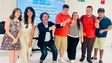 Grupo de jóvenes en taller de empleo en Cádiz con cartel de fondo.