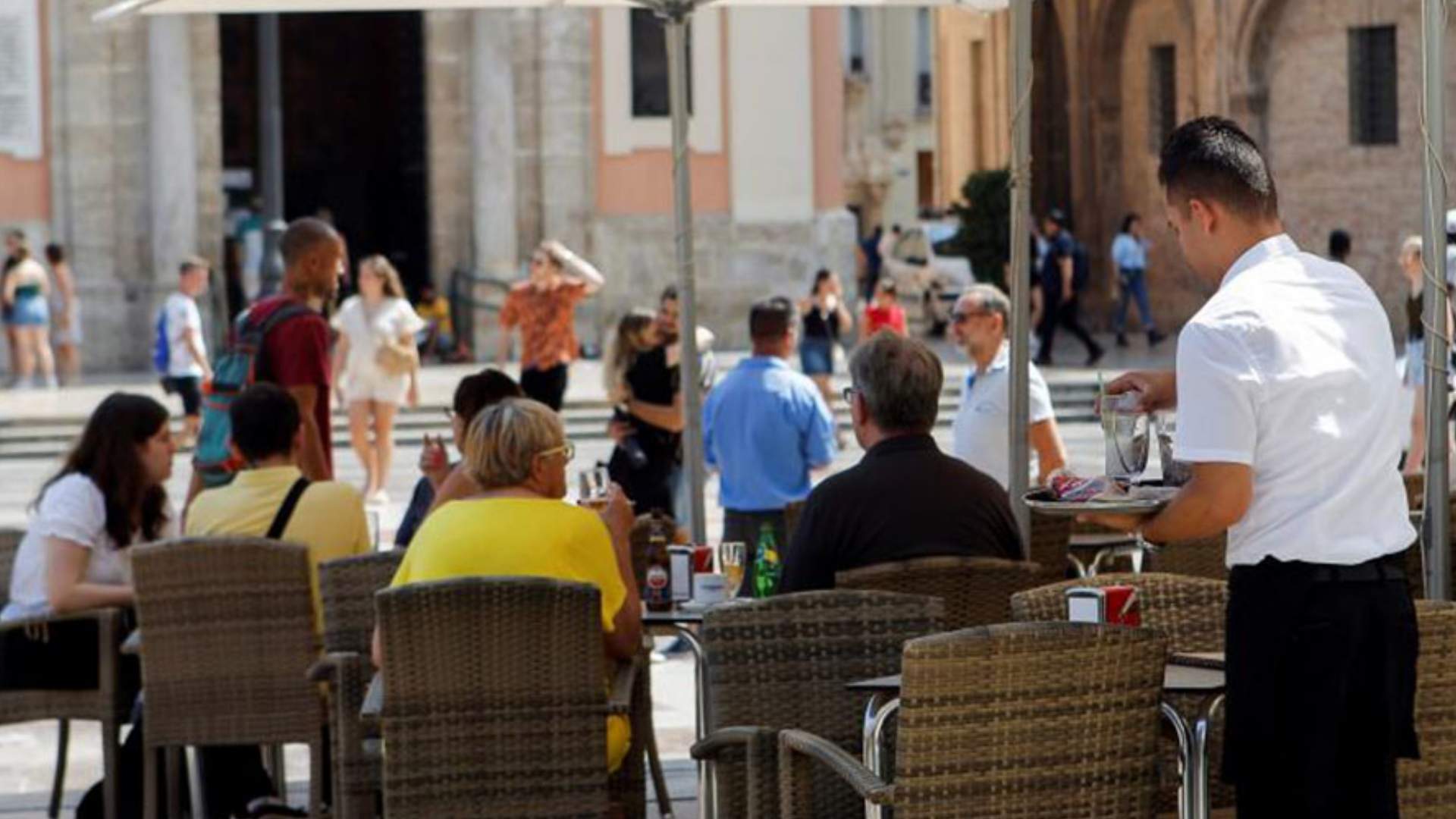 Camarero sirviendo en la terraza de una cafetería en Andalucía durante una época de descenso histórico del desempleo.