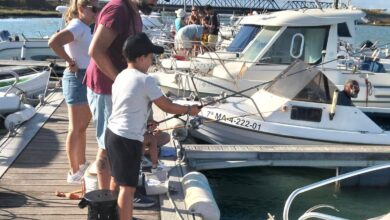 Niños y adultos pescando en el puerto de San Fernando.