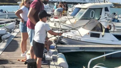Niños y adultos pescando en el puerto de San Fernando.