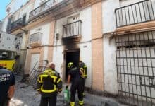 Bomberos en la entrada de un edificio afectado por incendio en El Puerto de Santa María.