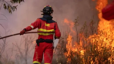 Bombero combatiendo un incendio forestal en Huelva con llamas y humo.