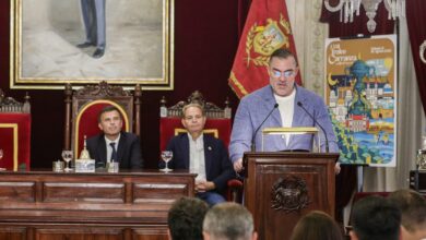 Autoridad en Cádiz hablando en un acto oficial con asistentes en el fondo.